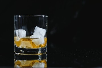 Whiskey glass black background shiny