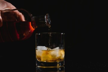 Whiskey glass black background shiny