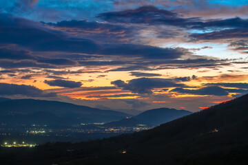 sunset in the mountains. Partly clouds in the blue and yellow sky at sunset. blue, yellow, orange sky.skyline . wide angle sky