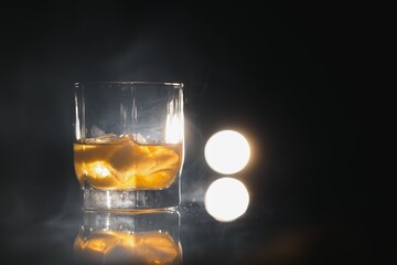 whiskey with ice on black background with smoke
