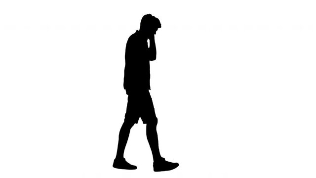 Silhouette Casual young man listening to music in headphones while walking.