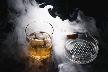 Whiskey drink with smoking cigar