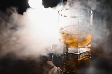 whiskey with ice on black background with smoke