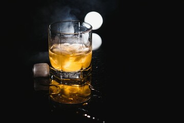 Whiskey glass black background shiny