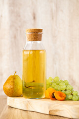 Homemade white wine or apple cider vinegar in a tall bottle with a wooden stopper.