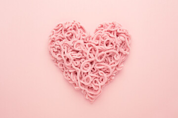 Valentines Day Heart made of yarn on pink background. Copy space, Flat lay. Compound love symbol.