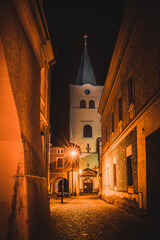 View of the dominant church in the middle of the town of Valasske Mezirici during the night the church is illuminated in yellow.