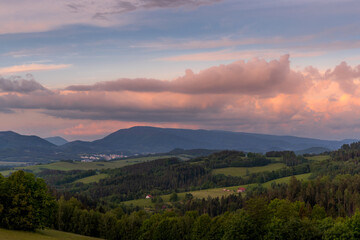 Landscape full of hills and mountains with clouds and blue sky with sun during colorful sunset Beskydy region.