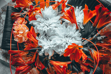 Decorated with a large bouquet in hand of red and white flowers and with accessories wrapped in wrapping paper.