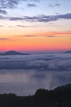 美しいグラデーションの空と眼下の湖の上に浮かぶ雲。トワイライトの自然の明媚。