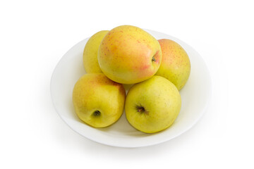 Yellow apples on a dish on a white background