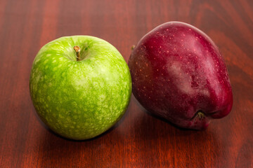 Green and red apples on dark wooden table close-up
