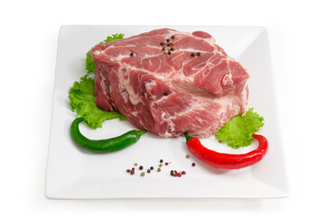 Piece of uncooked pork neck with spices on square dish
