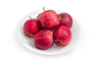 Red apples on a dish on a white background