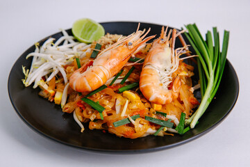 Udon Pad Thai Shrimp Black Plate White background Asian food
