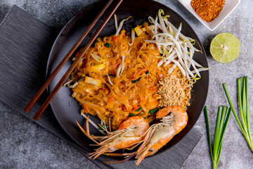 Udon Pad Thai with shrimp in a dark background, top view Asian style food Copy space