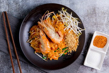 Udon Pad Thai with shrimp in a dark background, top view Asian style food Copy space