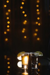 Tasty alcohol drink cocktail tequila with lime and salt on vibrant dark background. Closeup.