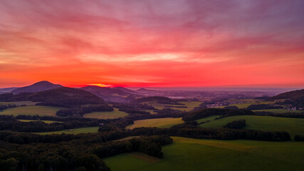 Plakat Aerial view of colorful clouds and mountainous hilly landscape at sunset over the horizon of Beskydy region.
