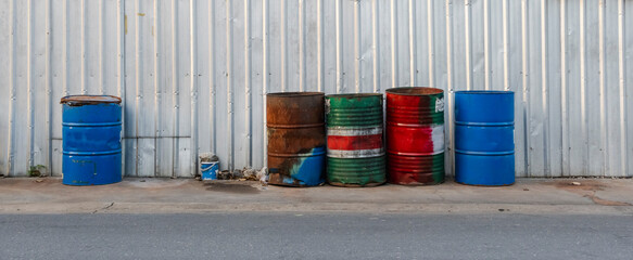 Rusty oil drum lined up for garbage collection