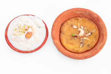 Special Indian Mawa Malpua Mithai Soaked In Sugar Syrup Cheeni Ki Chashni or Chaashni Served With Thick Milk Rabdi Or Rabri In Eco Friendly Terracotta Pot. White Background With Copy Space For Text