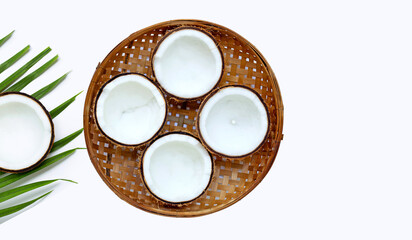 Half coconuts on wooden bamboo threshing basket on white background. Copy space