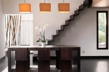 Zen interior dining room with orchid and modern stairs
