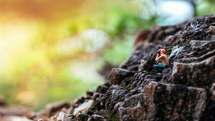 Miniature photographer taking photo of beautiful landscape