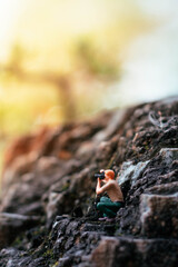 Miniature photographer taking photo of beautiful landscape