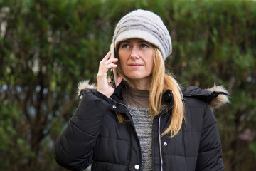 portrait of smiling woman with hat and mobile phone