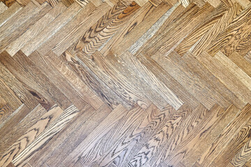 Elegant vintage oak wooden block parquet floor with traditional herringbone pattern in light empty room close upper view