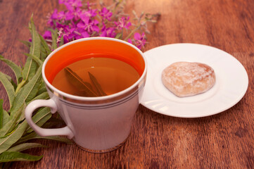 Still life photo with herbal tea from fireweed leaves and gingerbread on a wooden background
