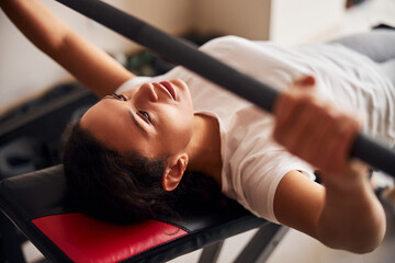 Professional sportswoman performing the barbell bench press