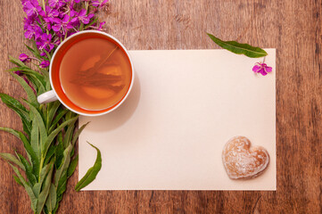 Still life photo with herbal tea from fireweed leaves and gingerbread on a wooden background
