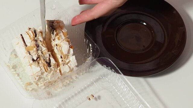 Slice piece of vanilla cake topping with white chocolate chips for coffee or tea break, on white with almond petals, coconut flakes, takes it out of the box, puts it on a saucer, eats, pours coffee