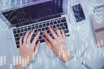 Double exposure of woman hands working on computer and forex chart hologram drawing. Top View. Financial analysis concept.