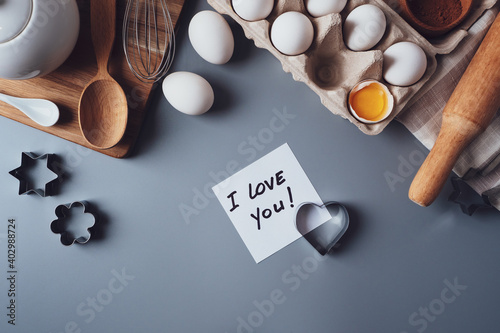 Note I love you. Ingredients for making homemade cookies on a gray background. The concept of cooking sweets for Valentine's day, Father's Day or Mother's Day. Flat lay, top view