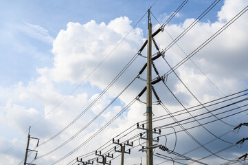 Fototapeta premium Electric poles and power line with cloud sky background.