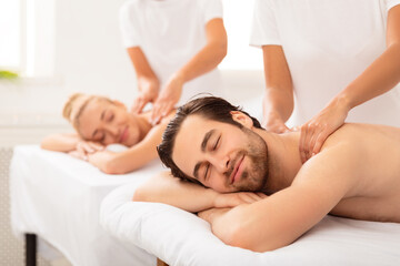 Obraz na płótnie Canvas Spouses Receiving Neck And Back Massage Lying At Spa