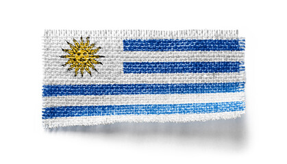 Uruguay flag on a piece of cloth on a white background