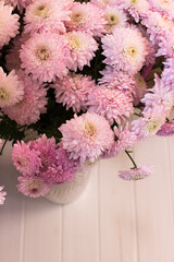 A bouquet of pink chrysanthemums in a vase on a white background view from above