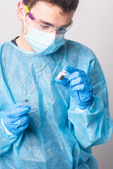The doctor looking at the vial to prepare the Covid-19 vaccine on a white background. Selective focus.