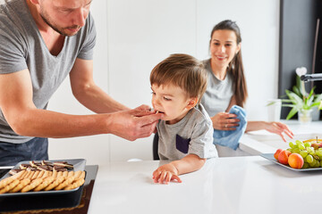 Vater gibt Kleinkind einen Keks zum Naschen