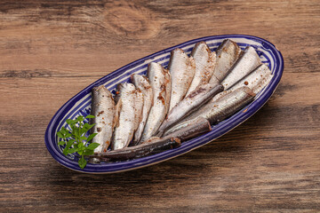 Anchovies in the bowl served basil leaves