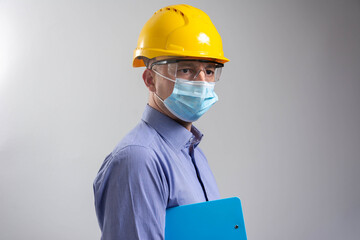 Fototapeta na wymiar Man engineer wearing safety mask isolated on white background with clipboard.