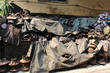 Pile of recycling car engine part metal waste on the old street under the daylight