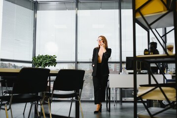 Confident business woman stands in the office