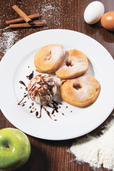 Delicious dessert donuts and ice cream on a white plate. Still life concept of restaurant serving. Close-up.