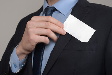 Businessman ,Business Man's hand hold showing business card - close up shot on grey background. Show a blank piece of paper. Paper visit card