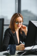 Pretty, nice, cute, perfect woman sitting at her desk on leather chair in work station, wearing...